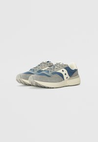 Gray and blue athletic shoes with a suede and mesh upper, cream accents, and a textured rubber sole. Features lacing and logo detail.