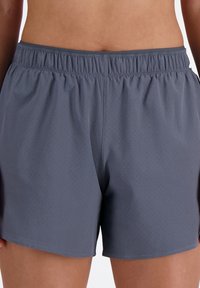 Herren Shorts, grau, aus leichtem Stoff mit perforierter Textur, elastischem Bund und lässiger Passform, geeignet für Sportbekleidung.