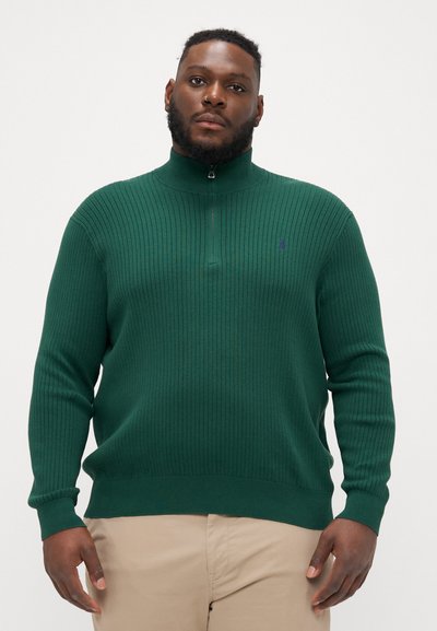 Maglione a coste verde scuro con colletto alto e mezza zip. Presenta un piccolo logo sul petto. Realizzato in un materiale morbido e testurizzato.