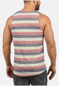 Herretanktop med horisontale striber i rød, marineblå og creme. Blødt stof, let design, med rund halsudskæring og ærmeløs skæring.