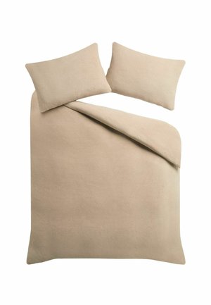 Couvre-lit beige à texture douce avec deux coussins rectangulaires assortis, un coin du couvre-lit replié.