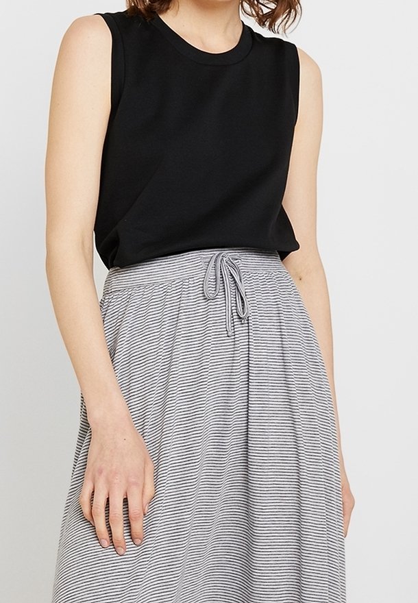 Zwart mouwloos topje gecombineerd met een lichtgrijs gestreepte rok, met een elastische tailleband en een trekkoorddetail.