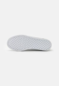 Semelle de sneaker en caoutchouc blanc avec un motif géométrique, présentant un design de grip texturé et une bordure lisse pour une durabilité améliorée.