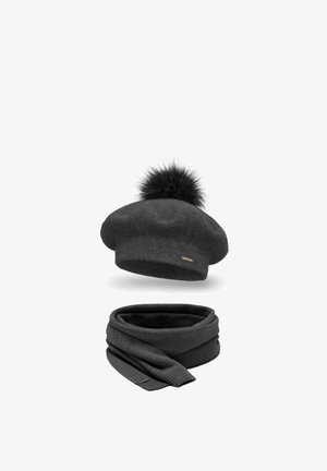 Beret de punto negro con un pompón de piel en la parte superior y una bufanda envolvente a juego en negro. Ambos artículos tienen una textura suave y un sutil detalle de marca.