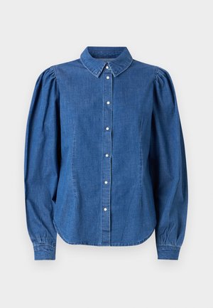 Džínová košeľa svetlomodrej farby, s gombíkmi vpredu a upraveným golierom. Obsahuje nadýchané dlhé rukávy a zakrivený lem.