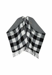 Poncho a scacchi bianco e nero con diversi motivi a quadri, dettagli in frangia lungo i bordi e una texture morbida.