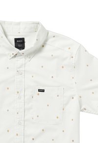 Chemise blanche à manches longues avec un petit motif losange orange et marron. Comprend une poche avant et un logo RVCA sur la poche.