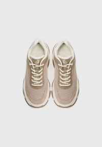 Béžové tenisky vyrobené z materiálů síťoviny a semiše, se zaoblenou špičkou, silnou strukturovanou podrážkou a bílými tkaničkami. Logo na jazyku a boku.