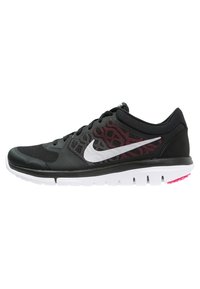 Zapatilla deportiva negra con parte superior de malla y acentos de patrón en rojo y negro, swoosh blanco de Nike y una suela media blanca con detalles en rosa.