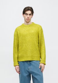 Erkollane soonikkoes lahtise lõikega kampsun, millel on sooniline tekstuur ja ümmargune kaelus. Omaduseks on pikad varrukad ja peen bränding rinna lähedal.