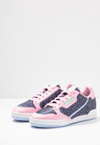 Tenisky v růžové a námořnické modré barvě s tečkovaným vzorem, s hladkou růžovou špičkou, světle modrými detaily a bílou gumovou podešví.