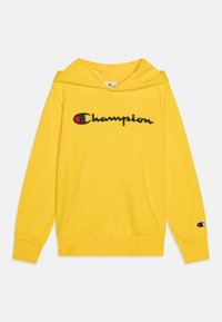 Felpa gialla con cappuccio, tasca anteriore e logo "Champion" ricamato. Polsini e vita a coste, texture del tessuto morbida.