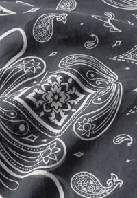 Grå stof med et hvidt paisley-mønster og blomsteraccenter, indviklede designs og diamantformer gennemgående. Blød tekstur, letvægtigt.
