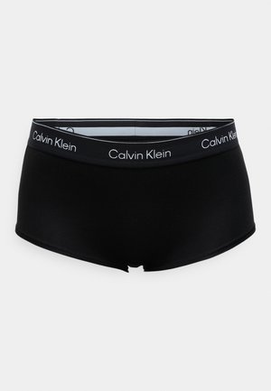 Sorte boxer briefs lavet af glat stof med en elastisk taljebånd med mærkning, der har "Calvin Klein" i hvid skrift.
