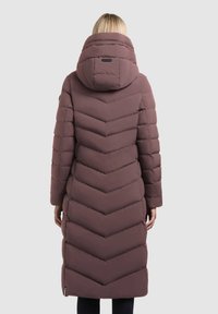 Lang, pufferjakke med chevron-mønster i dæmpet mauve, der har en stor hætte og stiksyninger for isolering. Glat tekstur og moderne design.