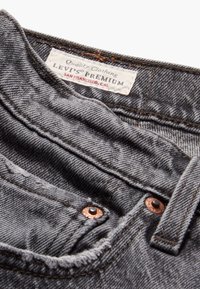 Grijze denimstof met een gestructureerde afwerking. Voorzien van een Levi's Premium label, koperen klinknagels en een uitgesleten zakrand.
