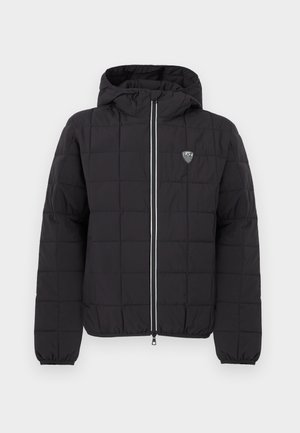 Black quilted jacket with a hood, featuring a front zipper, elastic cuffs, and a logo patch on the upper left side. Accented with white stripes.