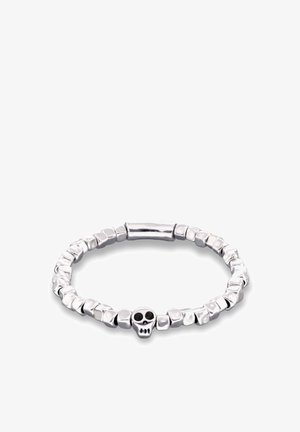 Brazalete de plata con una serie de cuentas texturizadas, con un pequeño detalle de calavera en el centro. Superficies lisas y facetadas que crean contraste.