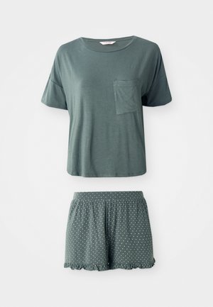Short-sleeve green pajama set with a chest pocket on the top and polka dot shorts with ruffled hem.