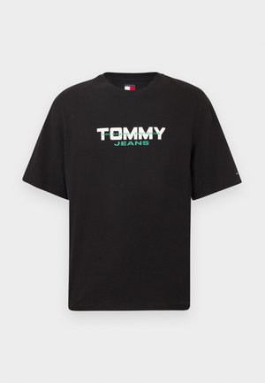 Mustast puuvillast lühikeste varrukatega T-särk, mille esiküljel on valgete ja roheliste paksude tähtedega kiri "TOMMY JEANS".