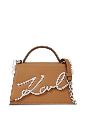 Sac à main en cuir tan avec quincaillerie en argent. Présente une poignée supérieure et une longue chaîne en sangle. L'avant affiche une signature stylisée "Karl".