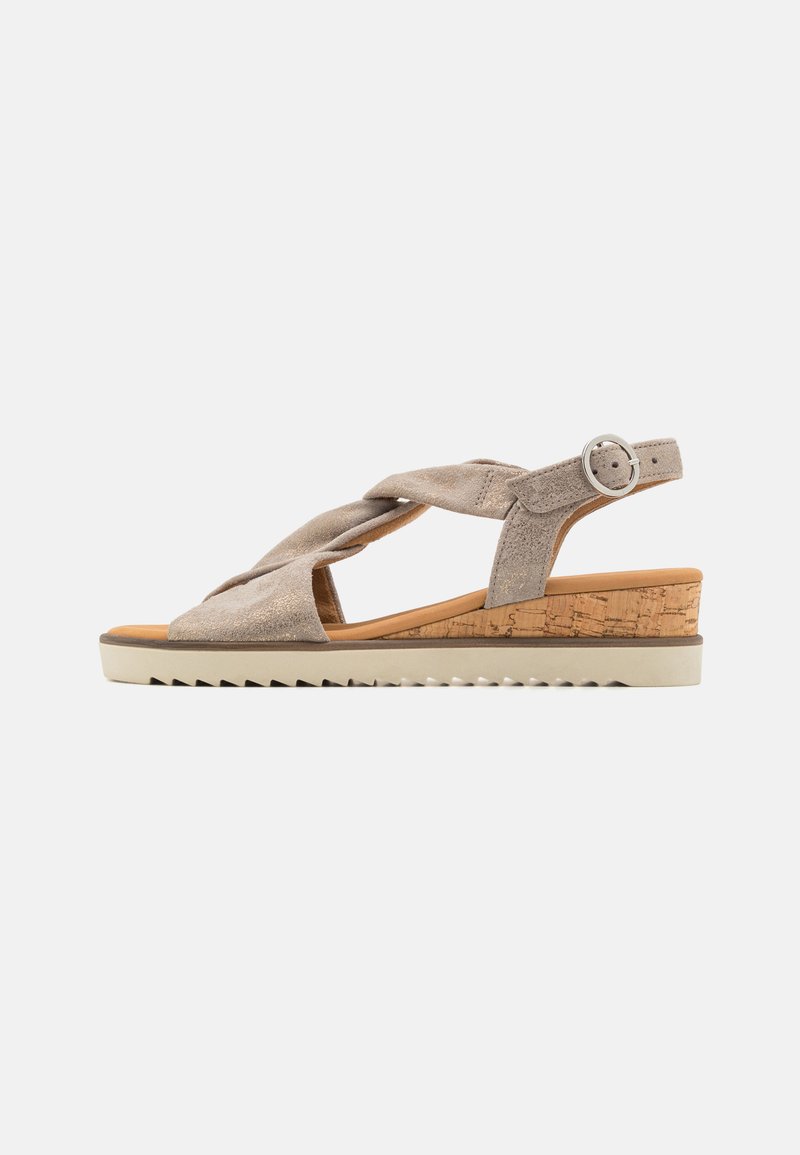 Beige suède wiggende sandalen met kruislings gespen, kurkdetails en een verstelbare enkelband. Textuur rubberen zool met gripgroeven.