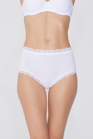 Donna che indossa biancheria intima di cotone bianca a vita alta con bordatura in pizzo e reggiseno bianco coordinato, su sfondo chiaro uniforme.