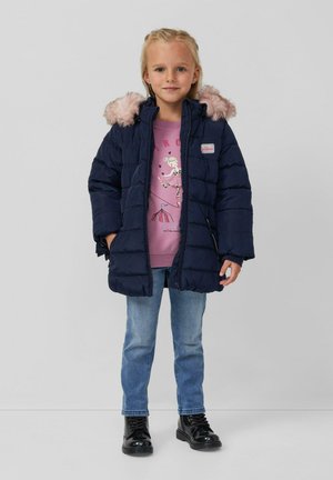 Marineblaue Steppjacke mit pinkem Kunstpelzkapuzenbesatz, ausgestattet mit einem Reißverschluss vorne und Seitentaschen, getragen über einem pinken T-Shirt mit Aufdruck und blauen Jeans.