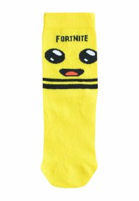 Kollane sokk, millel on lõbus näo disain suurte silmade ja väikese suuga, ning ülal on kiri "FORTNITE". Triibuline tekstuur.
