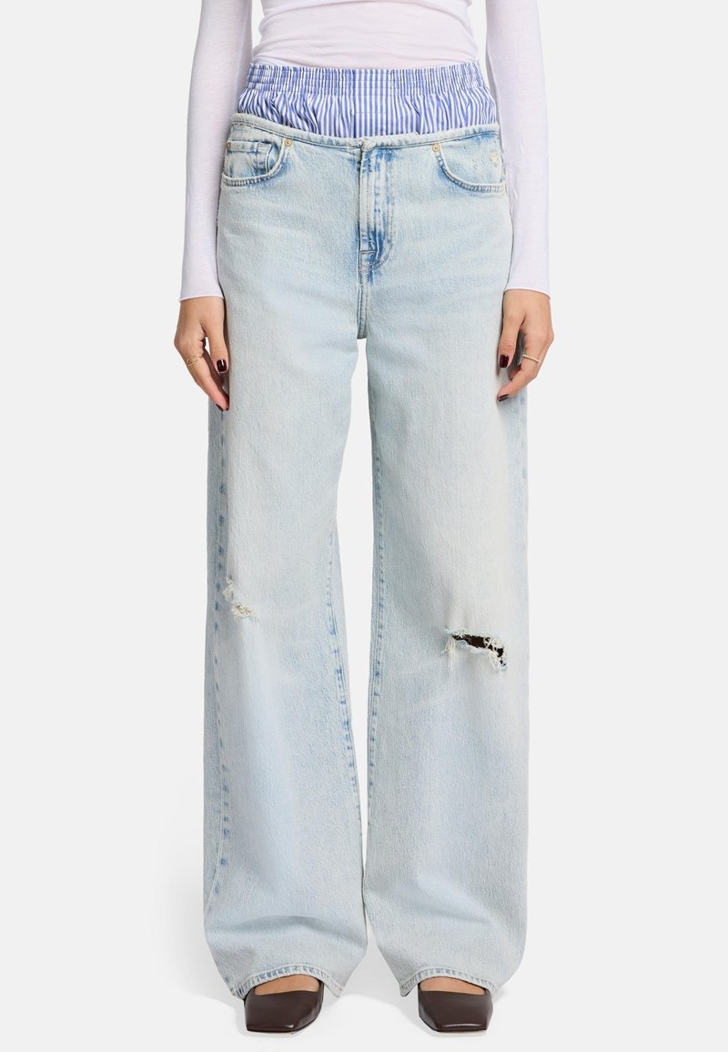 Helles blaues Weitbein-Jeans mit rissigen Knie-Details; dehnbarer Bund in blau-weißen Streifen; klassisches Fünf-Taschen-Design.