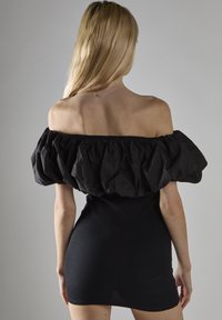 Czarna sukienka na ramiączkach z opadającymi rękawami, z teksturowanym, objętościowym puffed sleeve oraz dopasowaną, prążkowaną częścią ciała. Jednolity kolor z minimalnymi akcentami.