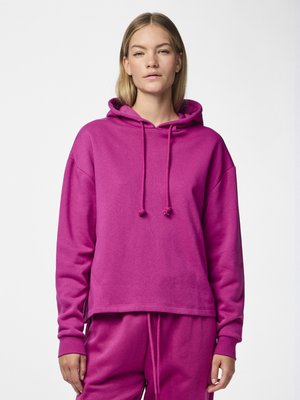 Hoodie fuchsia avec une capuche à cordon, coupe oversize, poignets côtelés et un ourlet droit, associé à un pantalon de jogging à cordon assorti.