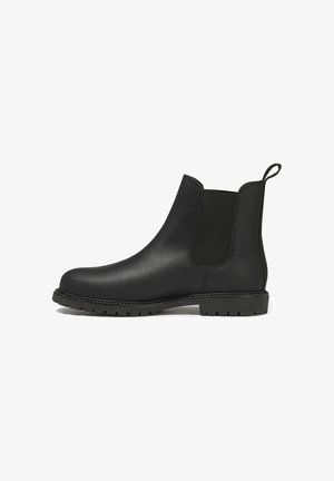 Botte Chelsea en cuir noir avec panneau latéral élastique, tirant à l'arrière et semelle en caoutchouc robuste pour une bonne traction.