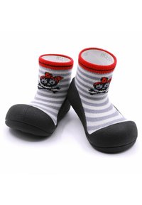 Calcetines de algodón con una suela de goma negra, rayas grises y blancas, borde rojo y un diseño de calavera de pirata en la parte frontal.
