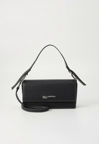 Fekete bőr kézitáska levehető pánttal, behajtós kialakítással, ezüst logóval és fehér díszítővarrással, sima felülettel.