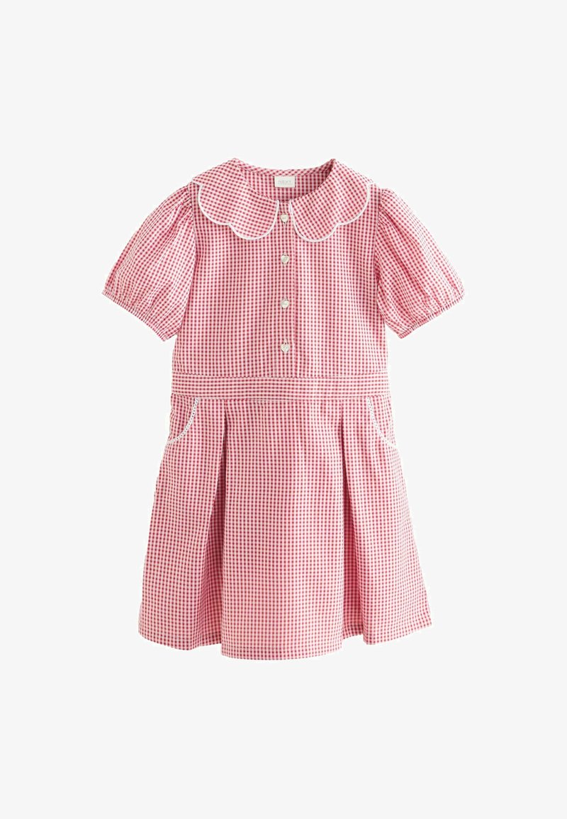 Červené a biele kárované šaty s krátkymi pufovanými rukávmi, vlnitým golierom, zapínaním na gombíky a bočnými vreckami. Priamy strih s plisovanou sukňou.