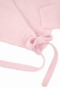 Rosa gestrickter Pullover mit einer weichen, strukturierten Oberfläche, ausgestattet mit einem Seitenschnürung und gerippten Bündchen. Das Material wirkt flauschig und gemütlich.