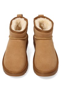 Pair of tan suede ankle boots with thick, soft cream-colored fleece lining and rubber soles, shown from above.