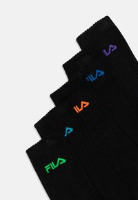 Črne nogavice do gležnjev z rebrastim vzorcem. Vsaka ima drugačno barvno "FILA" logo: zeleno, modro, oranžno in vijolično.
