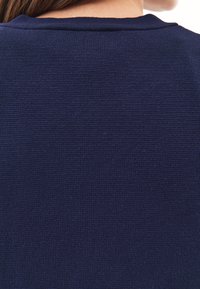 Granatowy sweter dzianinowy z okrągłym dekoltem i fakturowanym materiałem. Widok z tyłu ukazuje ribbowany kołnierz i bezszwowy fason.