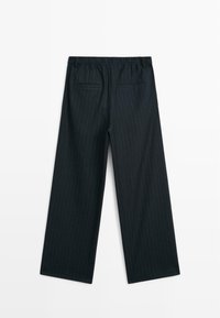 Bredde bukser i mørkeblå stof med pinstriber, med en strækbar talje og to baglommer. Glat tekstur.