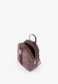 Zaino marrone trapuntato con cerniera, caratterizzato da un accento rigato rosso e nero e hardware dorato. Forma compatta con una sola maniglia.