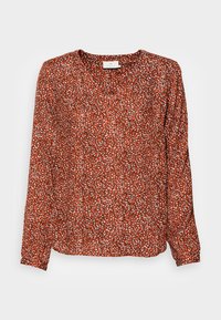 Blusa de manga longa com decote em V, feita de tecido leve. Apresenta uma base vermelha com um padrão abstrato em branco e preto ao longo de toda a peça.