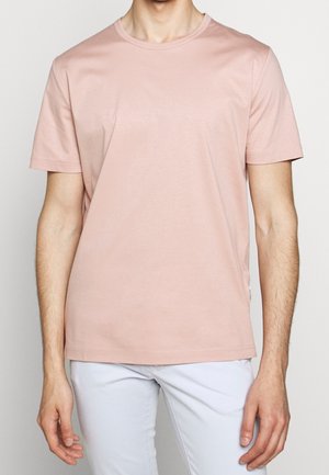 Jasnoróżowa koszulka z krótkim rękawem z miękkiej mieszanki bawełny, z okrągłym dekoltem i dopasowanym krojem. Minimalne przeszycie na dole.