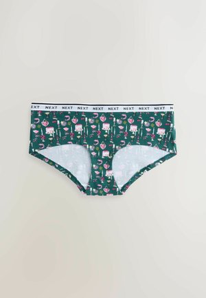 Zelené bavlnené spodné prádlo s hravým vzorom cupcakes, plameniakov a sŕdc. Biela elastická páska s nápisom „NEXT“.