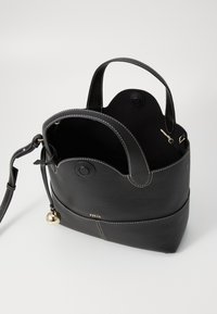 Zwarte leren tas met een gestructureerde afwerking, dubbele handvatten en een afneembare schouderriem. Bevat gouden hardware en zichtbare stiksels.