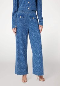 Blå denim vidbeniga byxor med ett subtilt fiskbensmönster, med framfickor, guldfärgade knappar och en midjehöjd av medelhöjd.