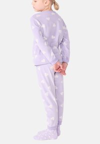 Set di pigiami lilla chiaro con motivi a forma di cuore bianchi. Maglietta a maniche lunghe e pantaloni coordinati. Tessuto morbido con polsini e colletto a coste.