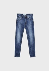 Jeans skinny blu sbiaditi con bottone frontale, cerniera, design a cinque tasche e cuciture visibili, distesi su uno sfondo grigio chiaro.