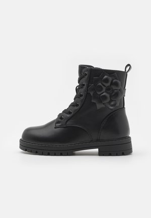 Black leather ankle boots featuring a rounded toe, lace-up front, and a decorative flower accent on the side. Sturdy treaded sole.